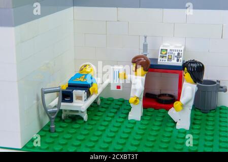 Florianopolis, Brazil. September 19, 2020: Doctor minifigure delivering prescription medication for pain relief to patient lying on stretcher in hospi Stock Photo
