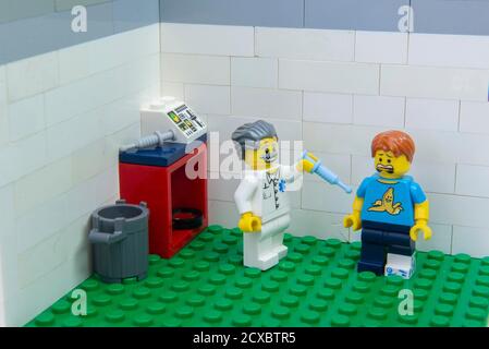 Florianopolis, Brazil. September 19, 2020: Minifigure of an injured patient lying in a hospital afraid of the injection in the nurse's hand. Vaccinati Stock Photo