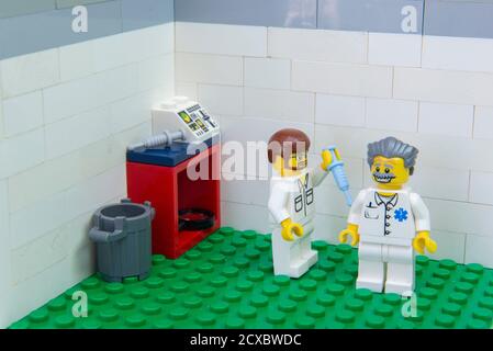Florianopolis, Brazil. September 19, 2020: Nurse minifigure applying Covid-19 test vaccine to a elderly doctor. Health workers and elderly people belo Stock Photo