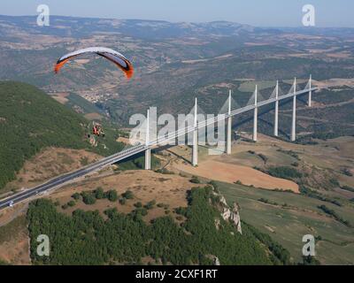 AIR-TO-AIR VIEW. Paramotor flying in the vicinity of the Millau Viaduct, the world's tallest bridge as of 2020. Millau, Tarn Valley, Aveyron, France. Stock Photo