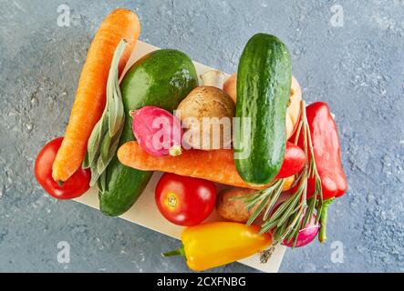 Various vegetables and fruits lying on a wooden podium, on a blue-gray background. Close up. Flat lay Stock Photo