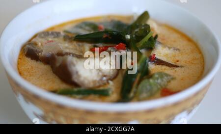 Sayur lodeh or curried vegetables on white background. Traditional Indonesian dish consisting of cabbage, long beans and eggplant,. Stock Photo