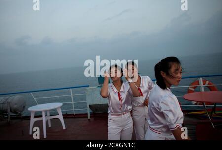 Workers of the Mangyongbyong cruise ship stand on the deck, near Mount Kumgang resort September 1, 2011. The North Korean state launched itself into the glitzy world of cruise tourism when about 130 passengers set sail from the rundown port of Rajin, near the China-Russia border, for the scenic Mount Kumgang resort near the South Korean border. Isolated North Korea's 'state tourism bureau' has teamed up with a Chinese travel company to run the country's first ever cruise aboard an ageing 9,700 tonne vessel which once plied the waters off the east coast of the divided peninsula shuttling passen