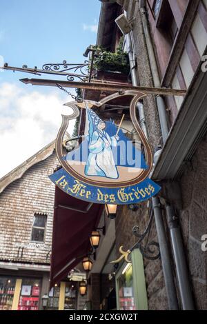 Le Mont-Saint-Michel, France - September 13, 2018: Artistically stylized advertising of restaurants and shops on the Grand Rue, the main street in Mon Stock Photo