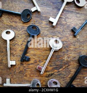 Many keys on brown wooden background . Stock Photo