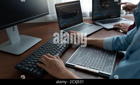 Team of Programmer working to find solution to problem and coding technologies in a software developing company office Stock Photo