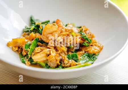 Stir fried flat noodles, shrimps, egg and vegetables with sweet black soybean sauce, called Pad Sea Ew Goog in Thailand language. Close up traditional Stock Photo