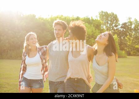 Happy young friends walking together in park Stock Photo