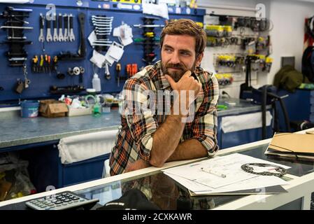 Owner standing in bicycle shop Stock Photo