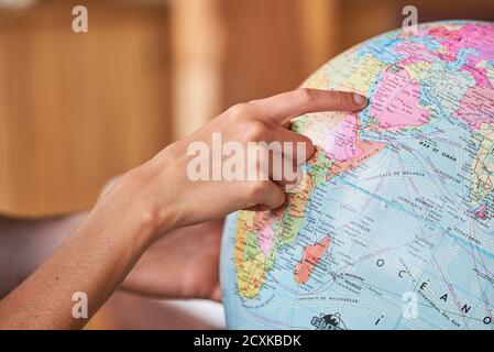 Couple's hands exploring world globe Stock Photo