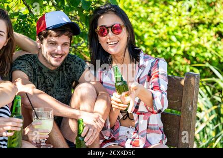 Young friends enjoying drinks at poolside Stock Photo
