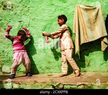 Nandgeon, India, Holi Festival, Feb 25, 2018 - Boy sprays his brother with color water during Festival of Colors in India Stock Photo