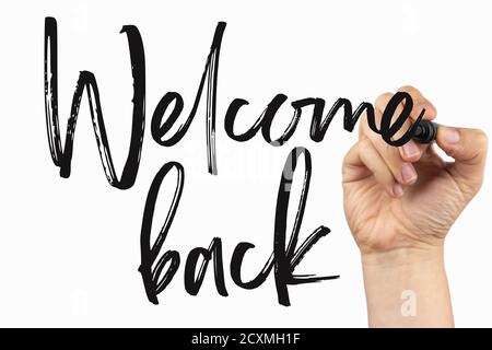 Welcome back to business or at home. Reopening concept. Doodle on a whiteboard, written with black marker in a hand. Scribble sketch text on a white b Stock Photo