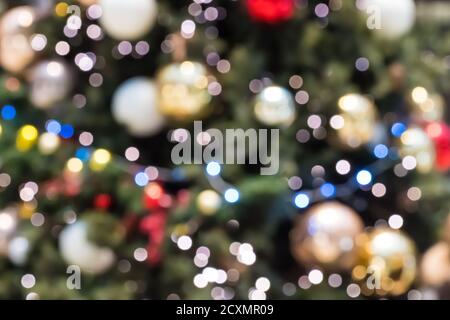 Blurred holiday background. Abstract christmas backdrop with defocused lights. Christmas tree out of focus with glowing lights. Festive bokeh lighting Stock Photo