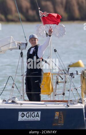 15-year-old Timothy Long waves as he sails his 28ft boat into Hamble Marina, Hampshire, becoming the youngest person to sail solo around Britain. Stock Photo