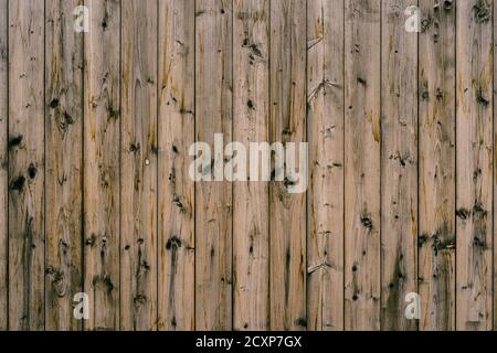 The texture of dark wooden planks knocked down in an upright position of brown color close-up. Stock Photo