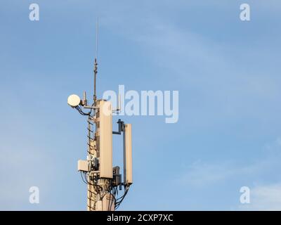 Mobile phone base station, equiped with 3G, 4G and 5G antenna, at the top of a European building, used for cellular phone network coverage, reception Stock Photo