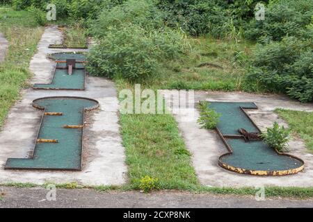 Abandoned mini golf course in a bankrupted resorts with decaying and rusting golf holes.  Picture of an abandoned resort for minigolf with abandoned f Stock Photo