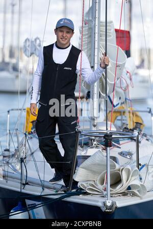 15-year-old Timothy Long poses for a photograph on his 28ft boat 'Alchemy' after arriving back into Hamble Point Marina, Hampshire, becoming the youngest person to sail solo around Britain. Stock Photo