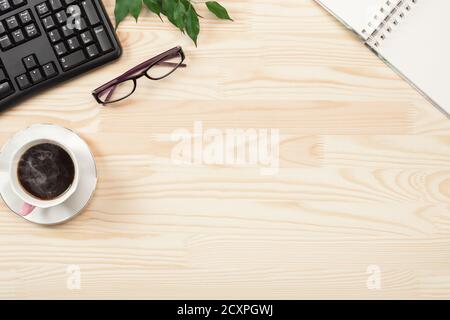 Wood office desk table with computer keyboard, cup of coffee and supplies. Top view with copy space, flat lay. office table concept Stock Photo