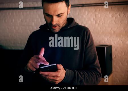 man in casual wear focusing on the mobile phone Stock Photo