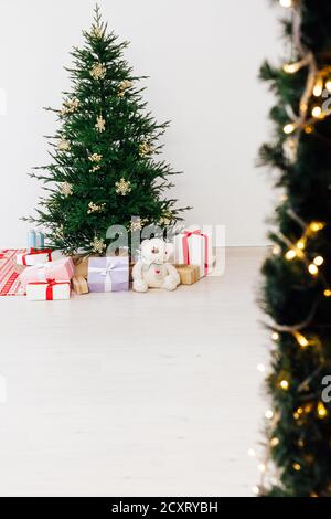 Stylish Christmas scandinavian minimalistic interior Christmas tree with light and bauble in sunny living room Stock Photo