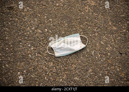 Used blue disposable face mask on road. The face masks used for the anti-corona virus. Stock Photo
