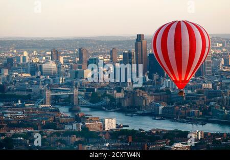 A hot air balloon rises into the early morning sky in front of the the city of London and Tower Bridge, July 25, 2011. Seven balloons took part in the flight over London as part of a collaboration between the London Sky Orchestra project, the 30th anniversary of the London International Festival of Theatre, and the Greater London Authority which is marking a year to go before the 2012 Olympic Games.   REUTERS/Andrew Winning (BRITAIN - Tags: TRANSPORT SOCIETY CITYSCAPE)