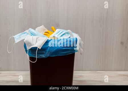 Used and contaminated surgical masks in the waste bin. Stock Photo