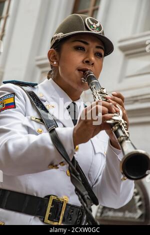 Cuenca, Ecuador - December 24, 2015 - Woman wears Ecuadorian Army uniform and plays the clarinet in parade Stock Photo