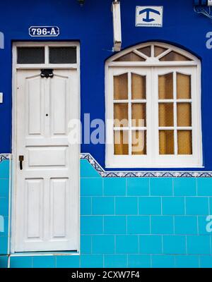 Trinidaad, Cuba Nov 26, 2017 - White door and window on blue wall. Sign above window indicates room for rent Stock Photo