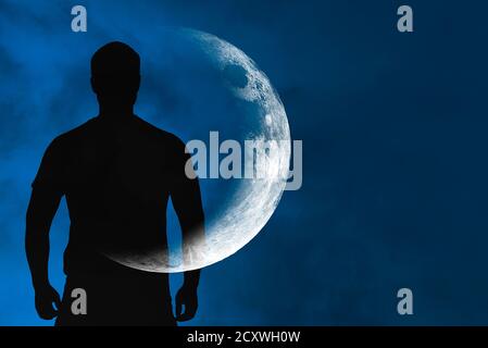 Silhouette of man with transparent crescent or moon on body in front blue sky during night, concept picture about space, astronomy and astrology Stock Photo