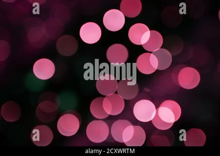 Abstract lights bokeh background in pink and green color on black Stock Photo