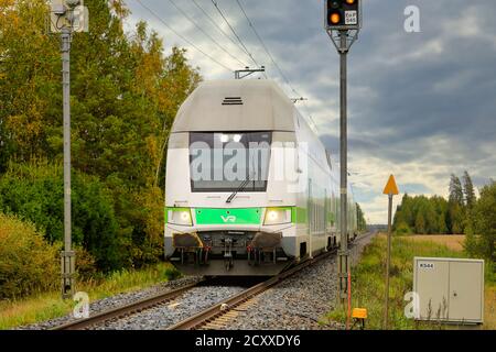 Modern VR Group Intercity electric 2 storey passenger train on the move at rural railroad crossing. Loimaa, Finland. September 18, 2020. Stock Photo