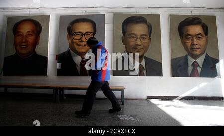 A man walks past portraits (R-L) of China's President Hu Jintao, Premier Wen Jiabao, former President Jiang Zemin and late Chairman Mao Zedong by Chinese artist Ye Zhifu outside a gallery in Beijing, January 18, 2011. Hu arrives in the United States on Tuesday for a four-day visit, with the centerpiece of the trip a formal state visit on Jan. 19 at the White House. REUTERS/Jason Lee(CHINA - Tags: POLITICS)