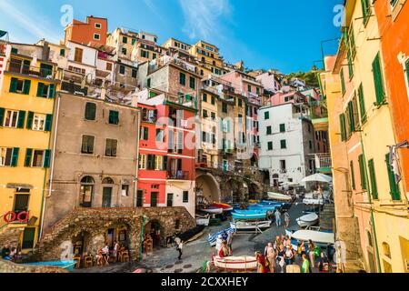 Picturesque view overlooking the popular road Via San Giacomo by the wharf, surrounded by the historic colourful tower houses built on rocks in... Stock Photo