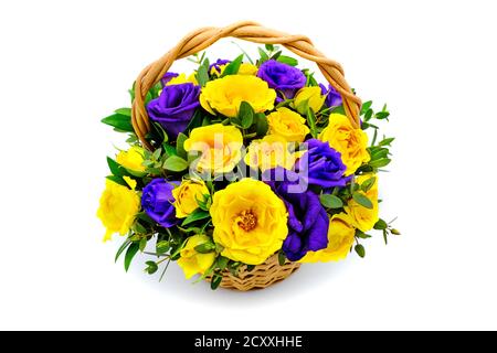 Basket with yellow and blue flowers on isolated white background. Bouquet of yellow and purple roses. Beautiful flowers in a wicker basket. Bouquet of Stock Photo