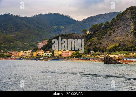 Lovely panoramic view of the sand beach, the colourful buildings, the famous Scoglio di Monterosso rock and the hills in the background of Fegina, the... Stock Photo