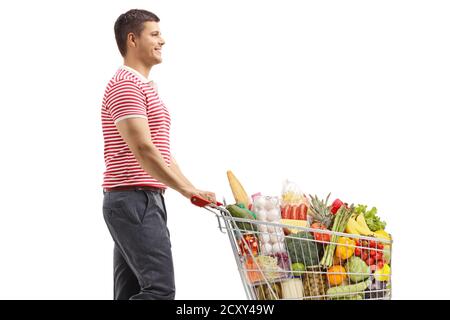 Man walking and pushing a full shopping cart isolated on white background Stock Photo