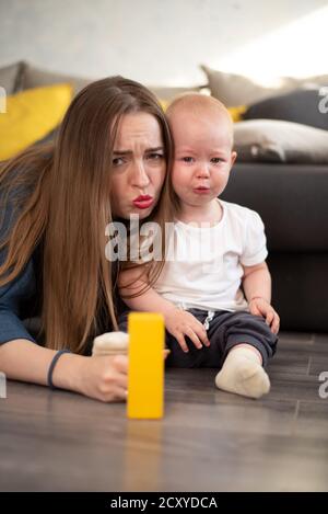 A young girl tries to comfort her little baby who is crying Stock Photo