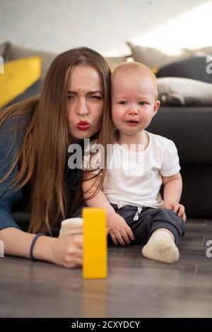 A young girl tries to comfort her little baby who is crying Stock Photo