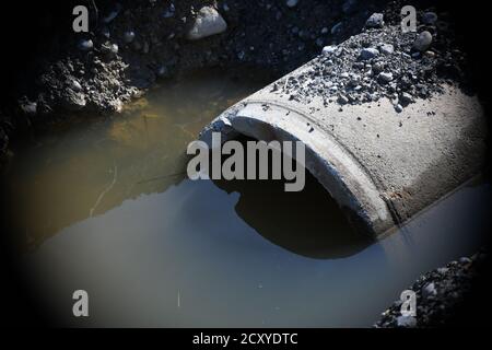 stehendes Wasser vor Kanalrohr auf einer Baustelle Stock Photo