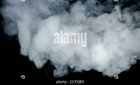 Dense smoke on black background captured in motion Stock Photo