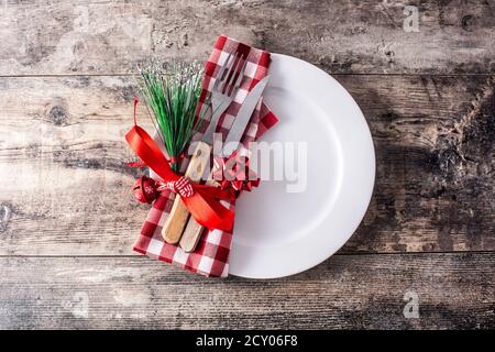 White plate, fork, knife and Christmas decoration on wooden background Stock Photo