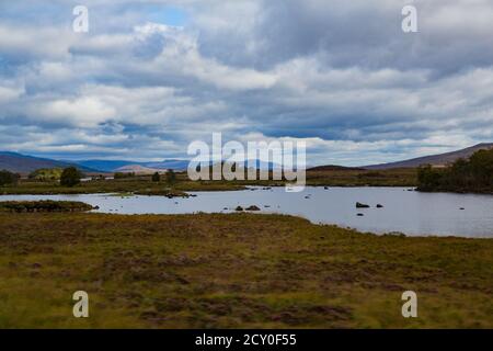 View of lake with hills on the horizon and clouds moving forward Stock Photo