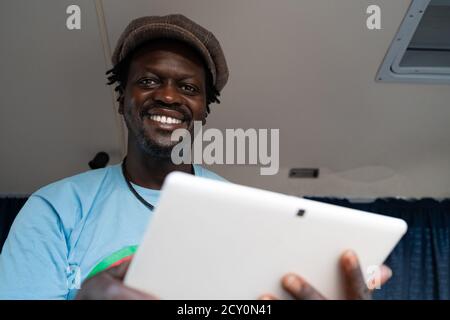 African black boy working with tablet inside a van Stock Photo