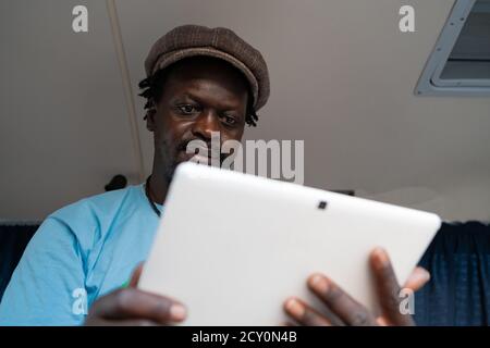 African black boy working with tablet inside a van Stock Photo