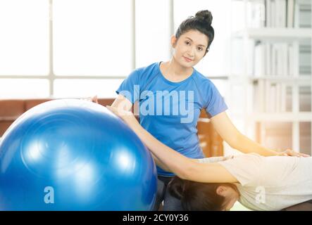 Woman working out with fitness ball of sportswomen practicing yoga. Stretching using fitness ball at home Stock Photo