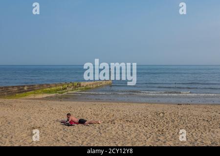 A solitary sunbather on an early summer evening on the beach at Southbourne in Bournemouth. 06 June 2016. Photo: Neil Turner Stock Photo