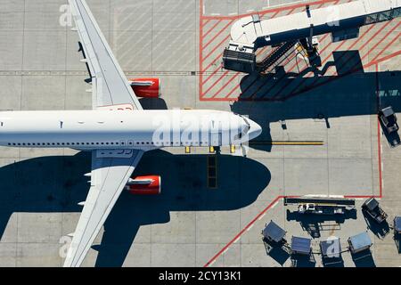 Aerial view of airport. Airplane is taxiing to gate of terminal. Stock Photo